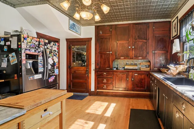 a kitchen with stainless steel appliances kitchen island granite countertop a refrigerator and a stove top oven