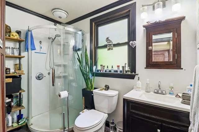 a bathroom with a sink a toilet and shower