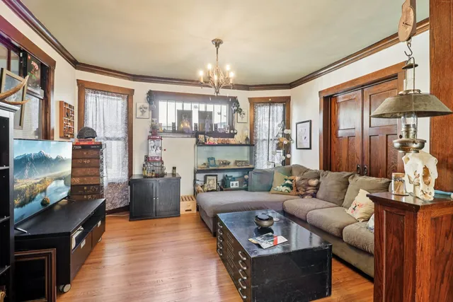 a living room with furniture a chandelier and a flat screen tv