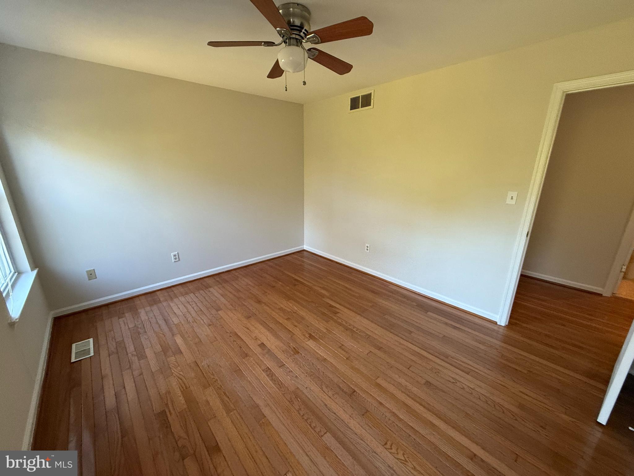 6375 Waterloo Road Elkridge, MD 21075 - Photo 13 of 18 an empty room with wooden floor and fan