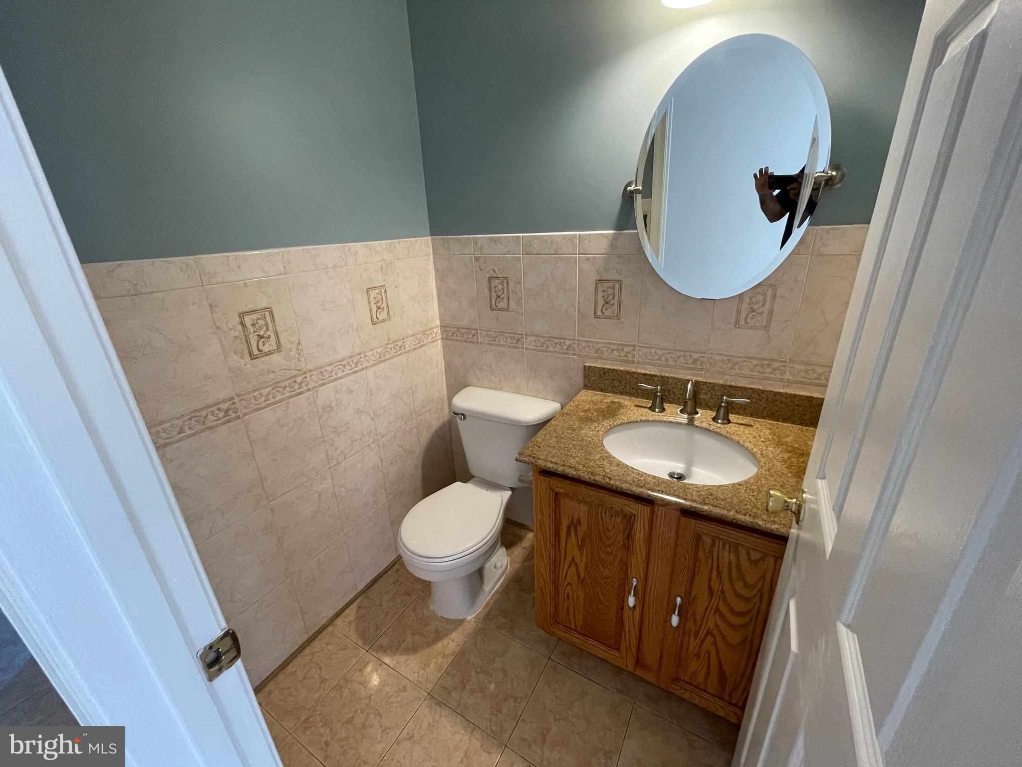 6375 Waterloo Road Elkridge, MD 21075 - Photo 14 of 18 a bathroom with a sink toilet a mirror and vanity