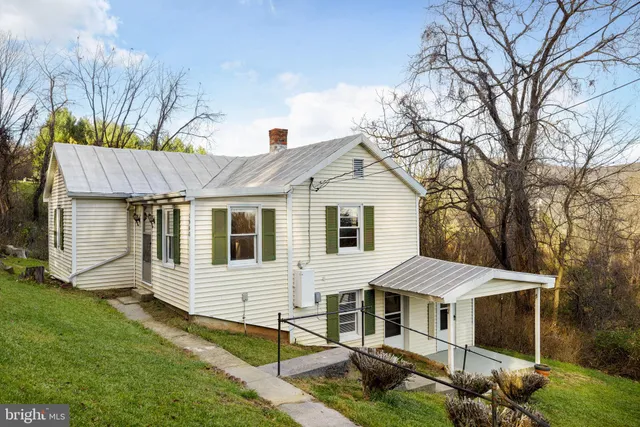 a view of a white house with a large window and a yard