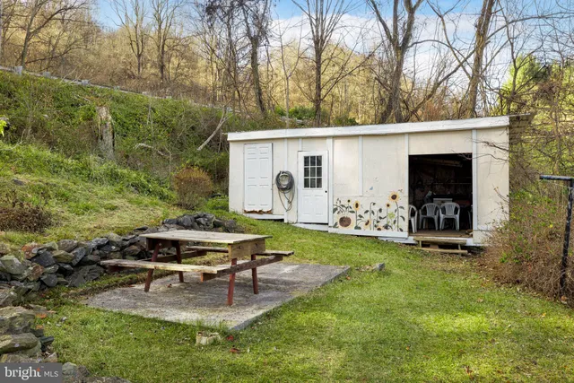 a view of a backyard with table and chairs and a fire pit