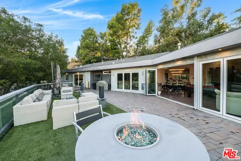 a kitchen with stainless steel appliances kitchen island granite countertop a table and chairs in it