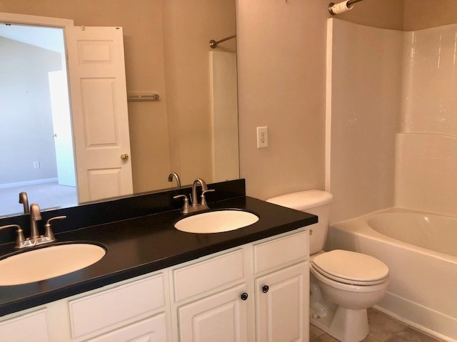 4235 Vienna Crest Drive Raleigh, NC 27613 - Photo 8 of 11 a bathroom with a granite countertop sink toilet a mirror and shower