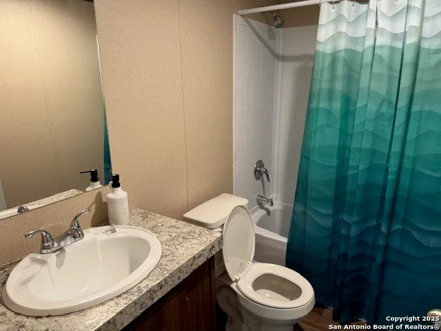 a bathroom with a granite countertop sink toilet and a mirror