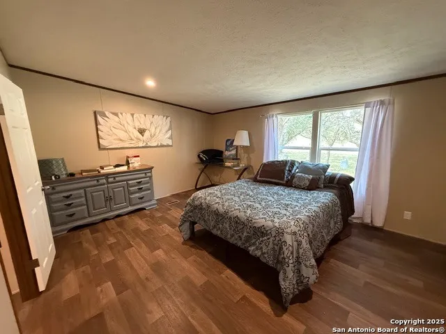 a bedroom with a bed window and dresser