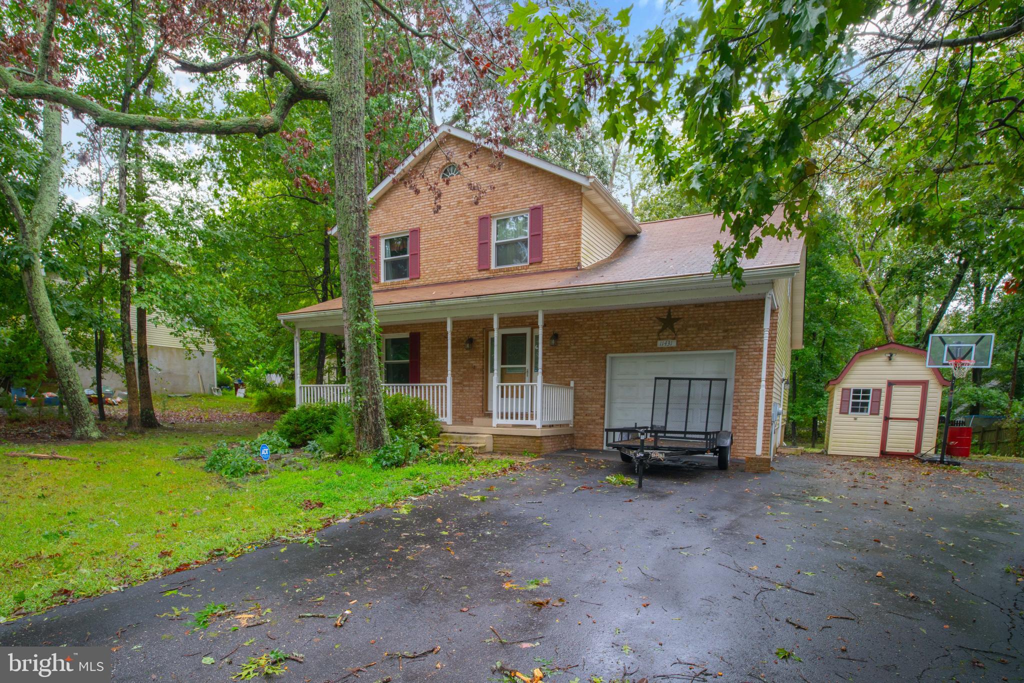 11431 Rawhide Road Lusby, MD 20657 - Photo 2 of 31 a front view of a house with a garden and porch