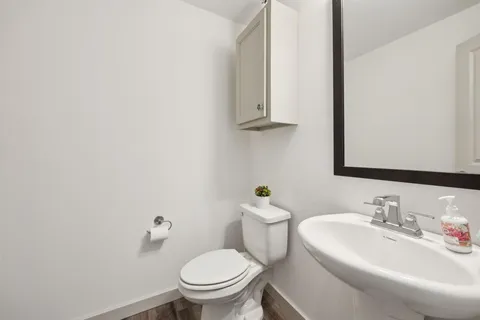 a bathroom with a sink a toilet and mirror