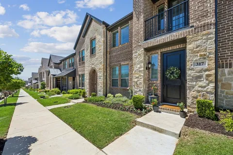 a front view of a brick house with a yard