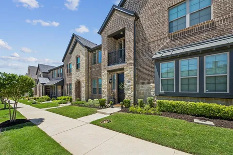 a front view of a brick house with a yard