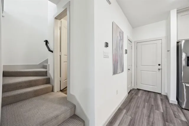 a view of a hallway with wooden floor and staircase