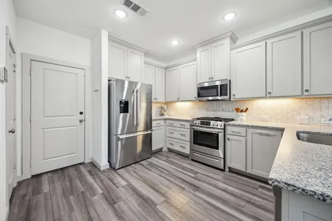 a kitchen with granite countertop a stove and a refrigerator