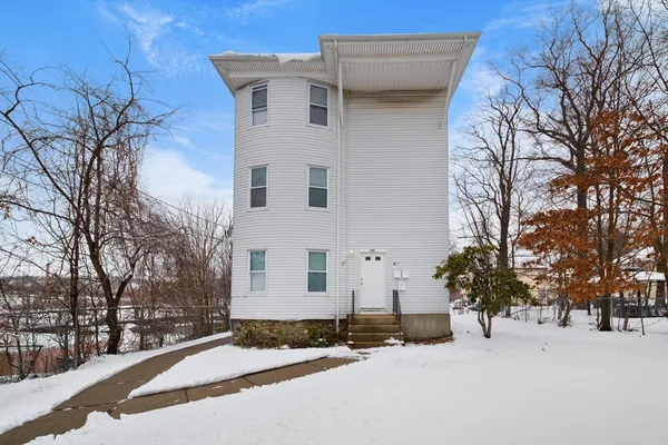 a front view of a house with a yard covered in snow