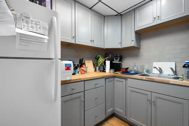 a kitchen with stainless steel appliances granite countertop white cabinets sink and a refrigerator