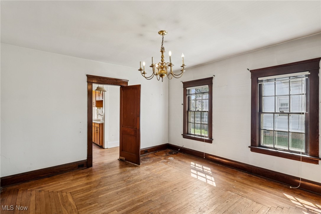 4040 Bayard Road Cleveland, OH 44121 - Photo 23 of 49 Spare room featuring a chandelier and wood-type flooring