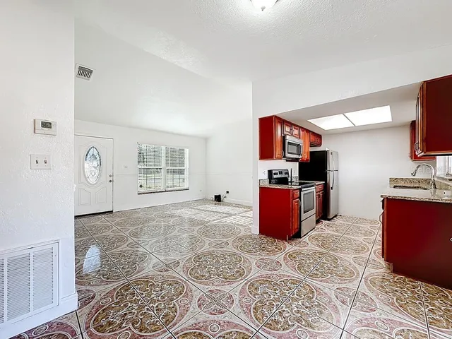 a kitchen with granite countertop a sink and cabinets