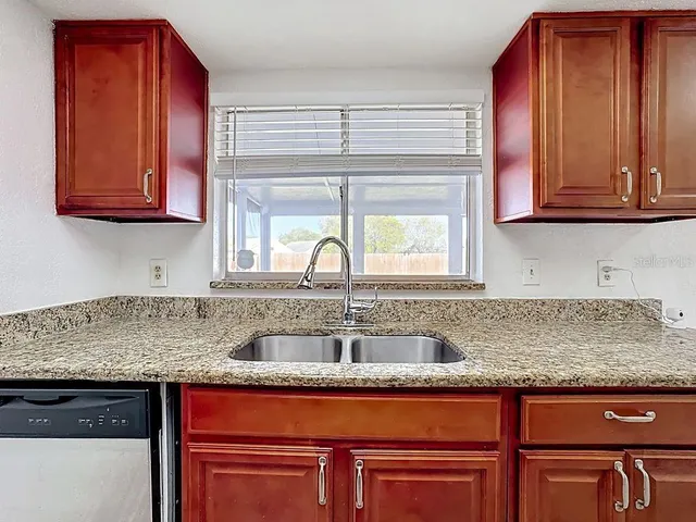 a kitchen with stainless steel appliances granite countertop a sink stove and cabinets