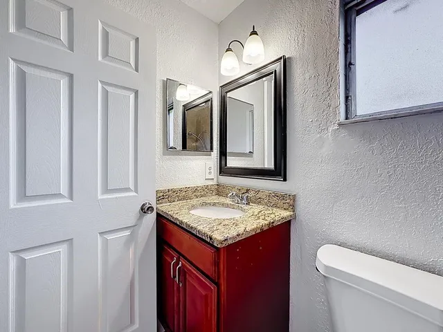 a bathroom with a toilet sink and mirror