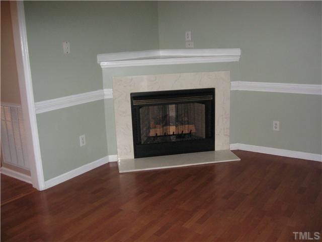Living room features a corner fireplace with marble surround and freshly painted. Note the beautiful floors.