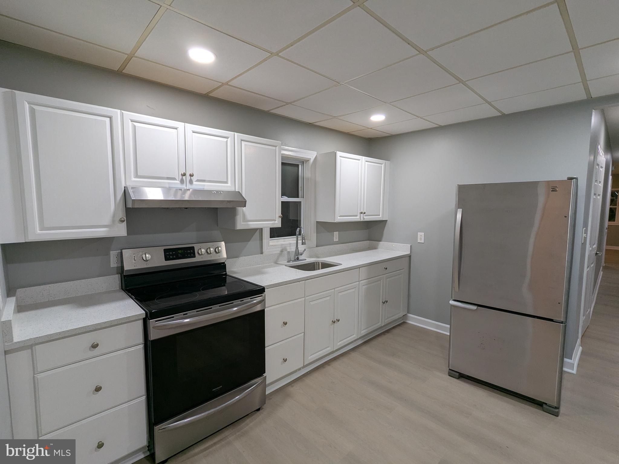 523 East Patapsco Avenue, Unit 1 Baltimore, MD 21225 - Photo 9 of 12 a kitchen with a refrigerator sink and cabinets