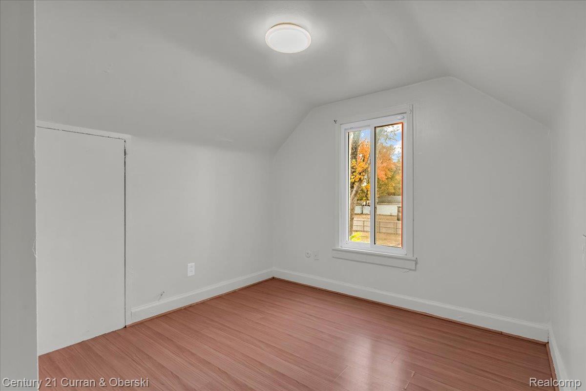 5580 South Merriman Road Wayne, MI 48184 - Photo 16 of 31 Sloped ceiling room featuring wood-finish flooring, a flush-mount ceiling light, and a single window with white trim
