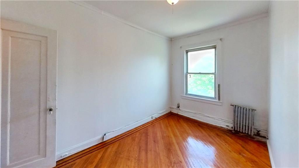 2552 East 19th Street Brooklyn, NY 11235 - Photo 16 of 34 an empty room with a window and wooden floor