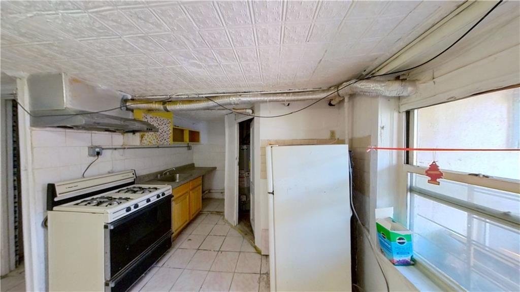 2552 East 19th Street Brooklyn, NY 11235 - Photo 29 of 34 a kitchen with stainless steel appliances granite countertop a refrigerator and a stove