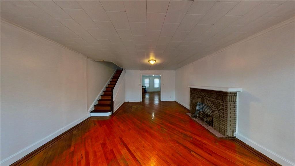 2552 East 19th Street Brooklyn, NY 11235 - Photo 3 of 34 a view of a livingroom with wooden floor and staircase