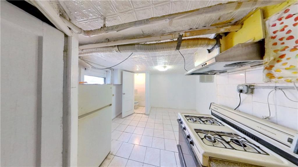 2552 East 19th Street Brooklyn, NY 11235 - Photo 31 of 34 a kitchen with stainless steel appliances granite countertop a stove and a refrigerator