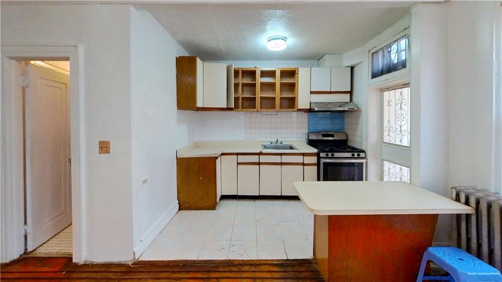2552 East 19th Street Brooklyn, NY 11235 - Photo 8 of 34 a kitchen with stainless steel appliances granite countertop a refrigerator a sink dishwasher a dining table and chairs with wooden floor