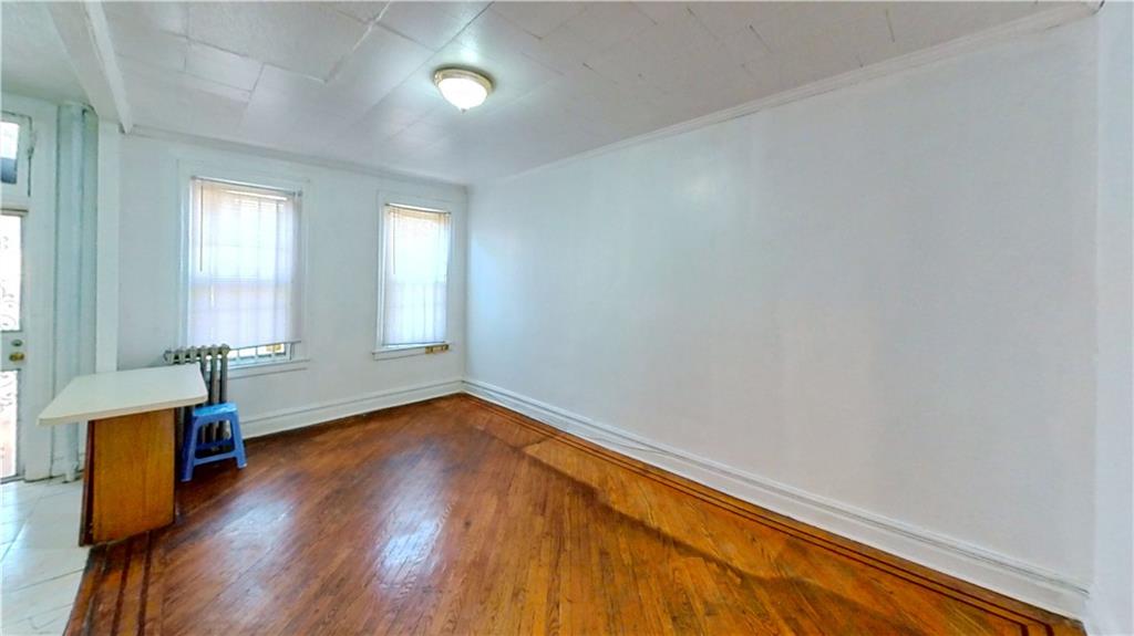 2552 East 19th Street Brooklyn, NY 11235 - Photo 9 of 34 an empty room with wooden floor and windows