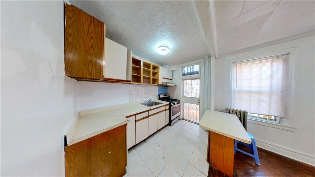 2552 East 19th Street Brooklyn, NY 11235 - Photo 10 of 34 a kitchen with stainless steel appliances granite countertop a sink and a stove