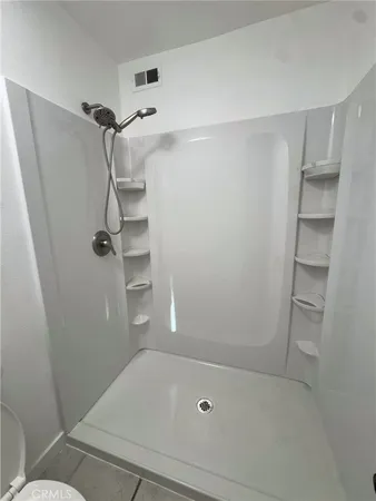 a bathroom with a granite countertop sink a toilet and shower