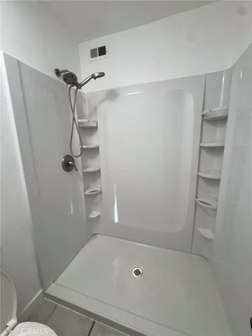 a bathroom with a granite countertop sink a toilet and shower