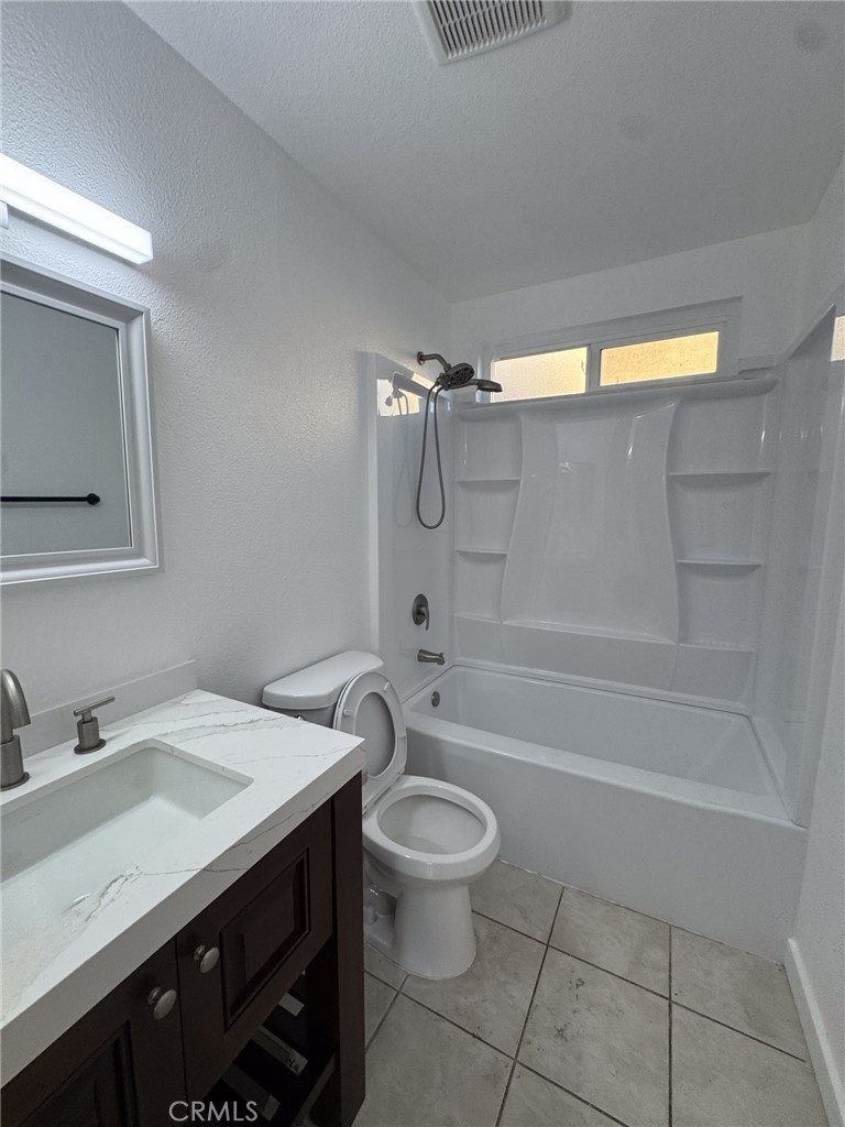 1215 South Athena Way Anaheim, CA 92806 - Photo 14 of 16 a bathroom with a granite countertop sink a toilet and shower