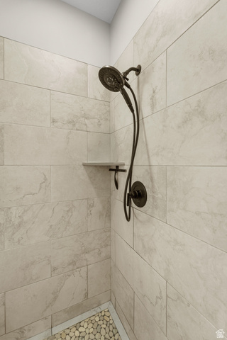 3678 Spiral Springs Road, Unit 204 Tooele, UT 84074 - Photo 30 of 59 Shower stall with light-toned rectangular wall tiling, a built-in corner shelf, and a dark bronze showerhead with an attached handheld sprayer