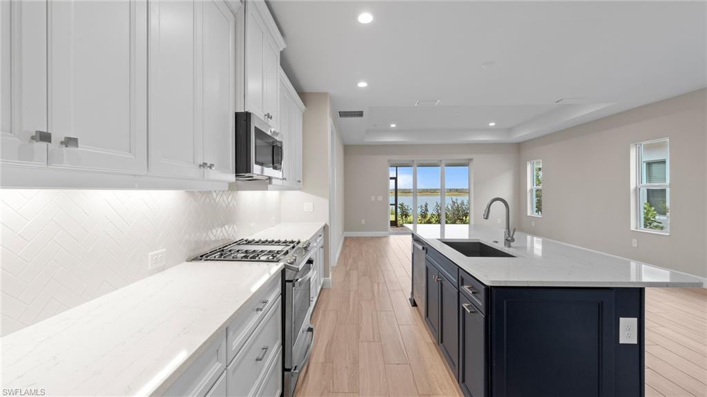4568 Centaurus Circle Naples, FL 34120 - Photo 14 of 47 a kitchen with granite countertop a sink stove and cabinets