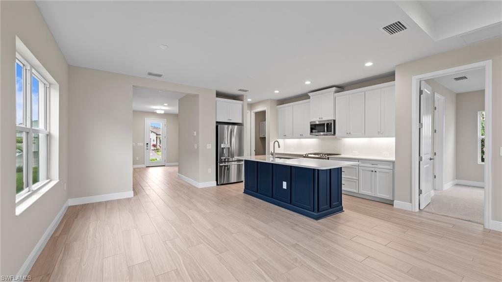 4568 Centaurus Circle Naples, FL 34120 - Photo 18 of 47 a room with stainless steel appliances kitchen island granite countertop a refrigerator and a sink
