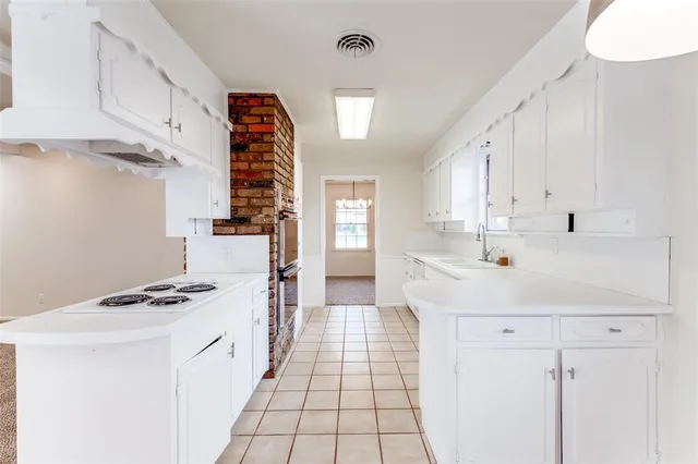 a kitchen with white cabinets and appliances