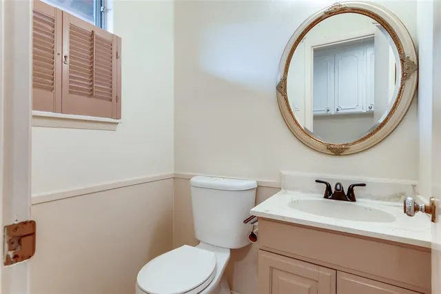 a bathroom with a sink mirror and toilet