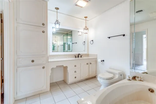 a spacious bathroom with a double vanity sink a toilet and a mirror