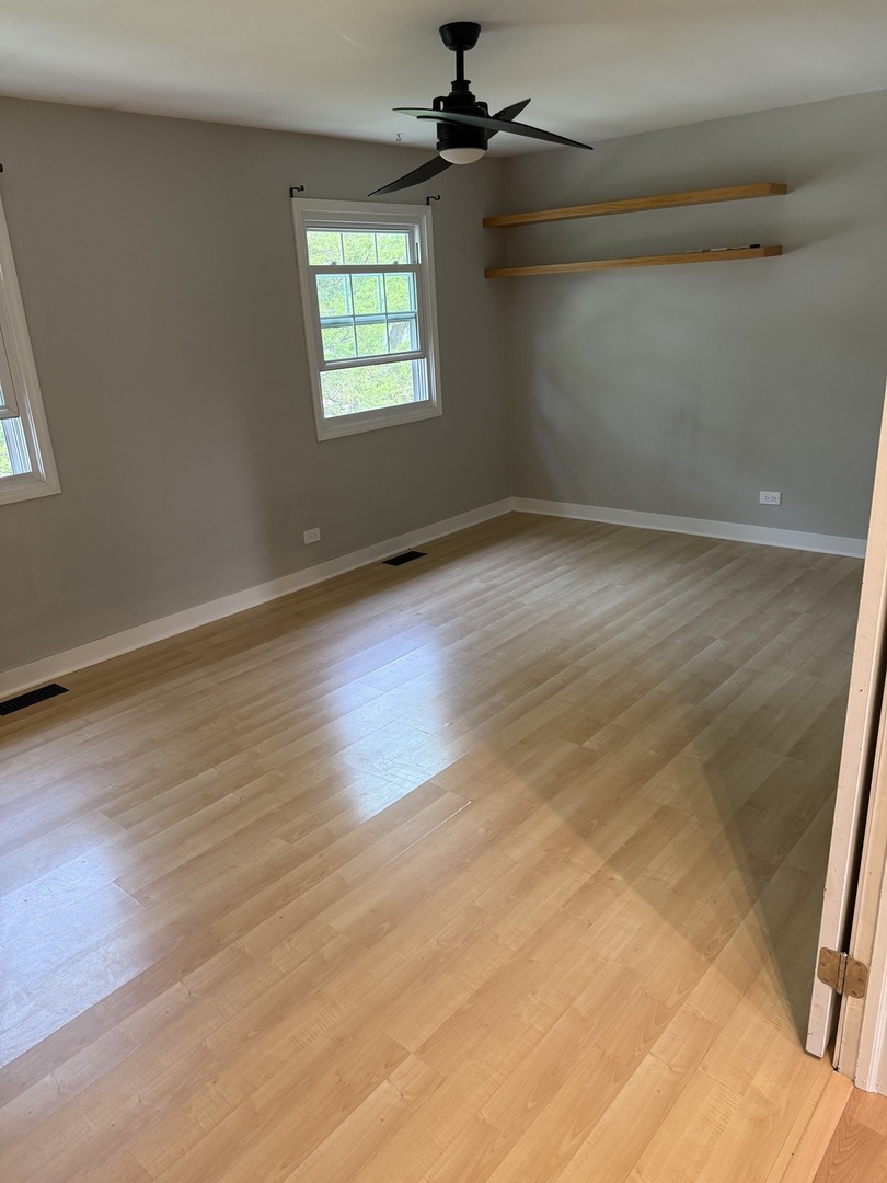 4539 Huntington Boulevard Hoffman Estates, IL 60192 - Photo 12 of 16 an empty room with wooden floor fan and windows