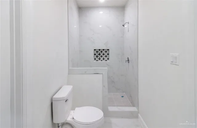 a white toilet sitting next to a bathroom sink