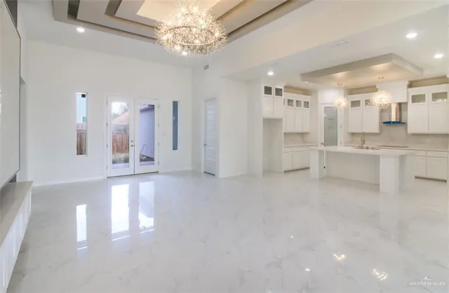 a view of a big room with chandelier and windows