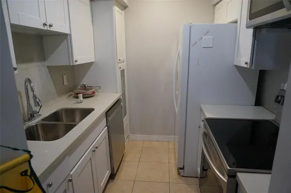 a kitchen with refrigerator and cabinets