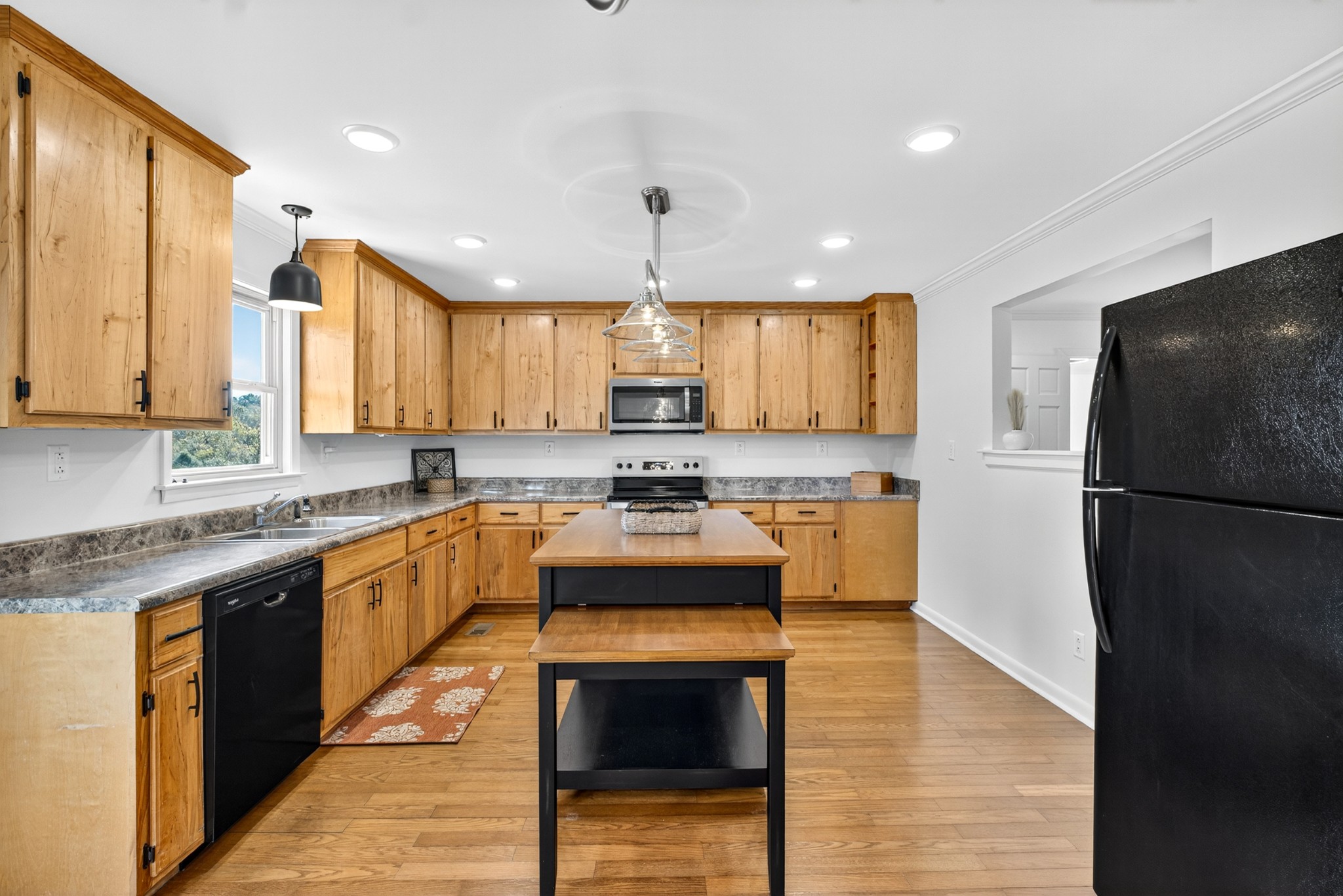 780 Champ Road Flintville, TN 37335 - Photo 14 of 45 a kitchen with stainless steel appliances granite countertop a refrigerator a sink dishwasher a stove oven and a dining table with wooden floor