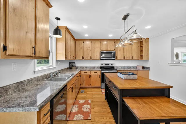 a kitchen with stainless steel appliances granite countertop wooden cabinets sink and stove
