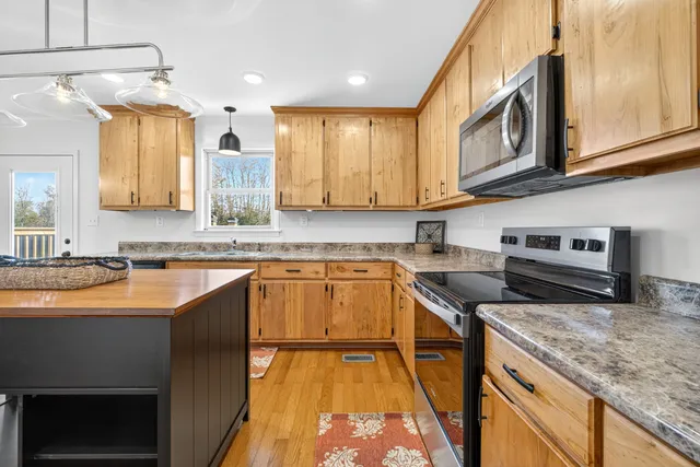 a kitchen with stainless steel appliances granite countertop a sink stove and cabinets