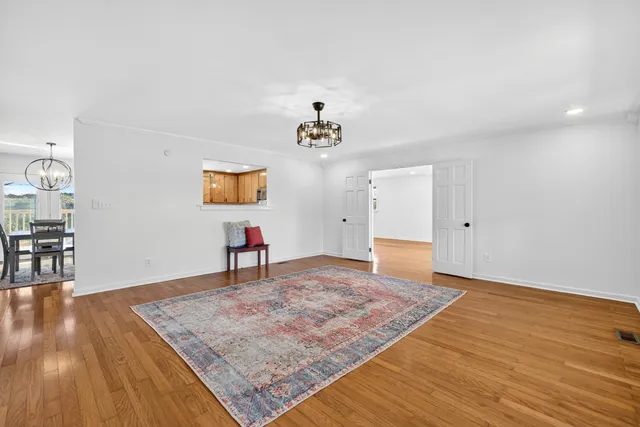 a view of a room with wooden floor and ceiling fan